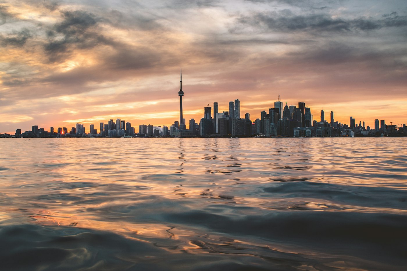 The Toronto skyline and CN Tower seen across Lake Ontario at golden hour